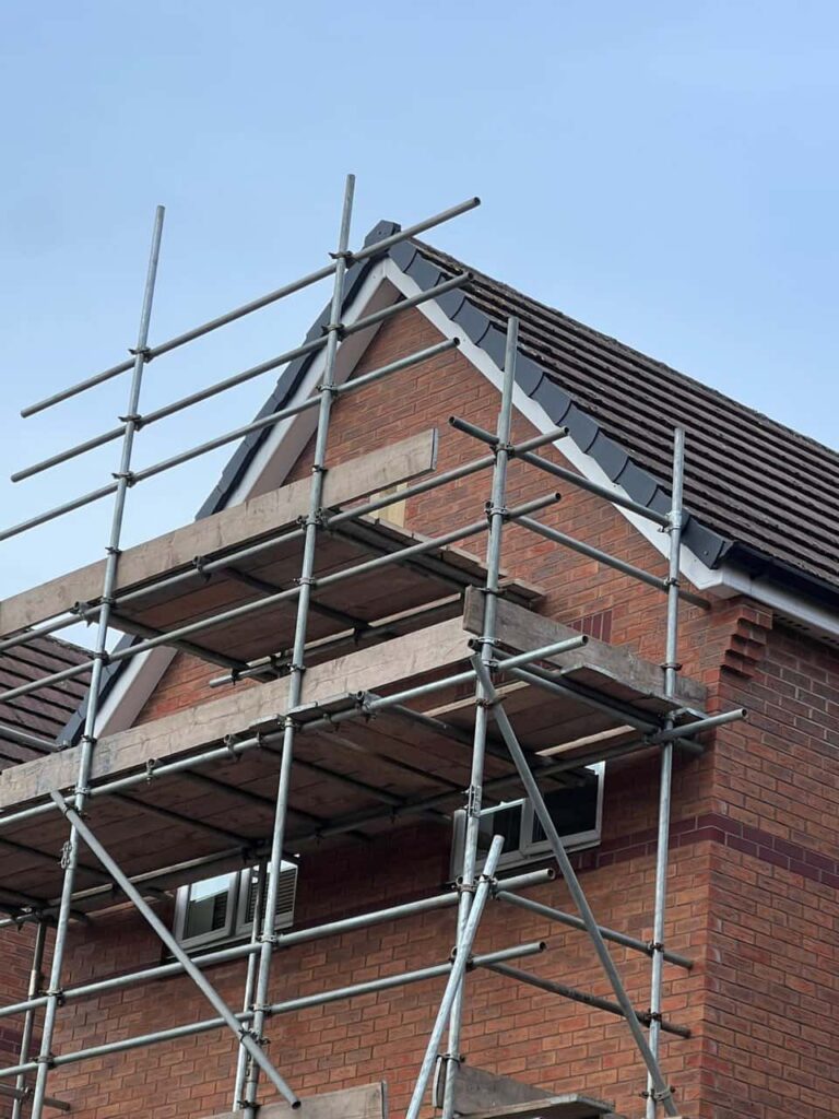 This is a photo of a roof which has just been repaired. There is a scaffold located at the gable end for access onto the roof. Works carried out by Caterham Roofing Repairs